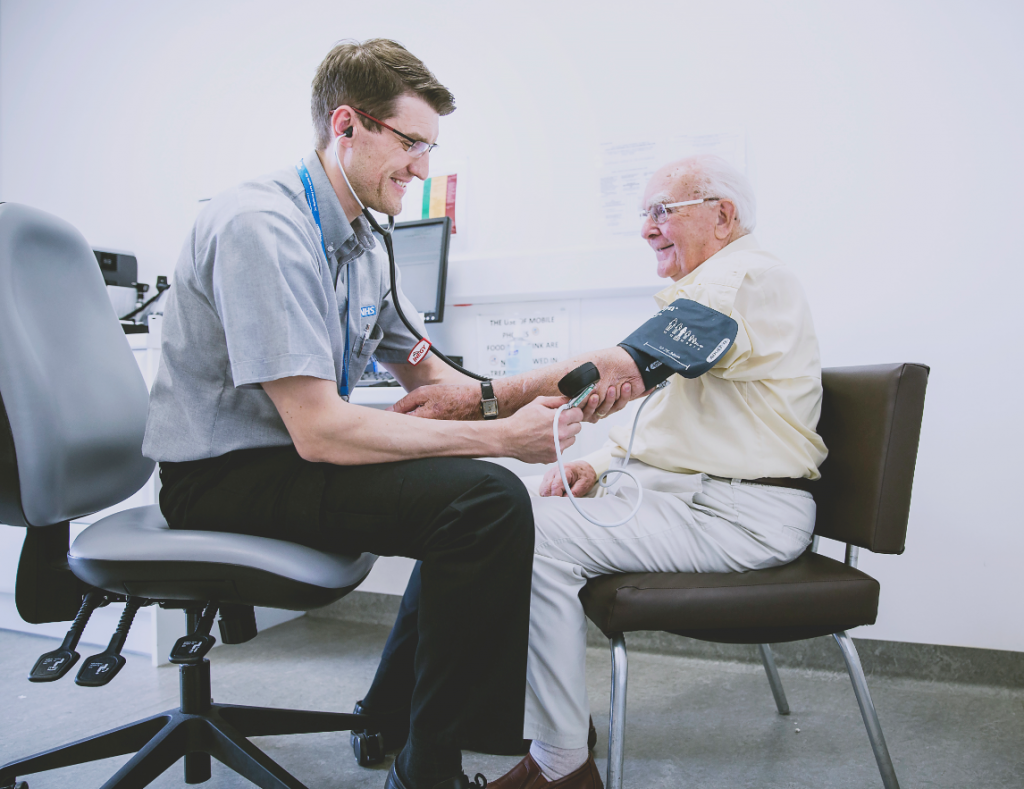 Doctor taking an older person's blood pressure.