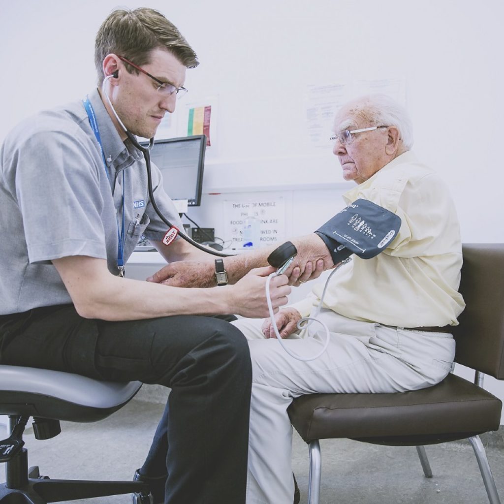 NHS Doctor takes patients blood pressure